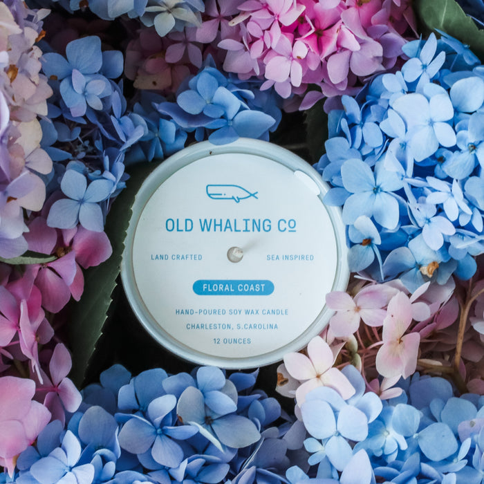Top view of Floral Coast Candle surrounded by blue and pink hydrangeas