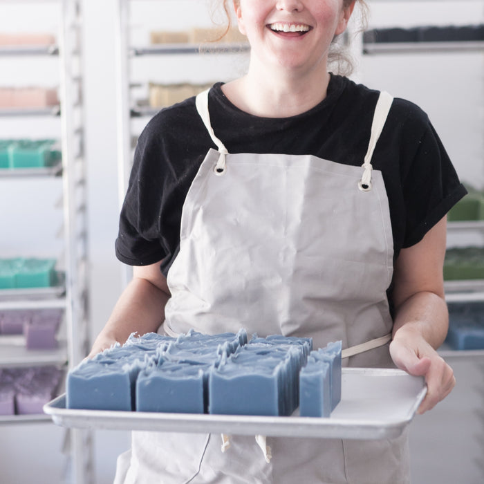 OWC Founder, April, holds tray of unboxed Oceanswept Bar Soaps while smiling