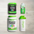 Orgain protein products including collagen peptides, organic protein powder, and a shaker bottle on a wooden surface.