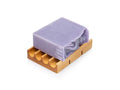 Lavender bar soap laying side down on wooden soap dish